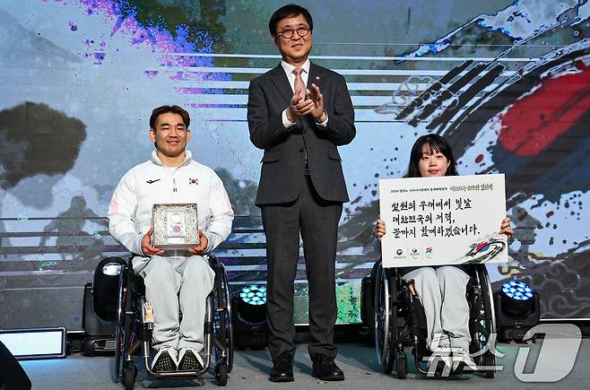 최휘영 문체부 장관이 2일 서울 송파구 올림픽파크텔에서 열린 2026 밀라노·코르티나담페초 동계 패럴림픽 대한민국 선수단 결단식에서 이용석, 김윤지 선수에게 격려선물 전달 후 기념촬영을 하고 있다. 2026.2.2/뉴스1 ⓒ News1 김도우 기자