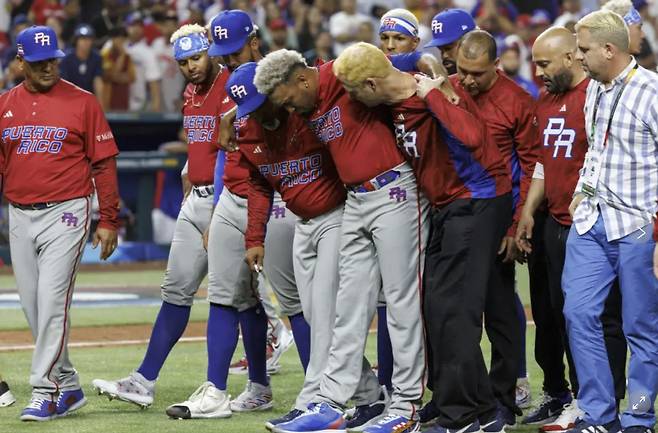푸에르토리코 에드윈 디아즈가 2023년 WBC 조별 라운드에서 도미니카공화국을 꺾은 뒤 세리머니를 하다 무릎을 다쳐 부축을 받으며 나가고 있다. AP연합뉴스