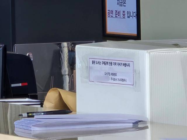 재선을 노리는 국민의힘 최민호 세종시장의 출판기념회가 열린 지난달 24일 세종 조치원읍 세종문화예술회관에 책값을 넣는 상자가 놓여 있다. 상자엔 행사 진행을 맡은 기획사 계좌번호가 적혀 있다. 세종=신은별 기자