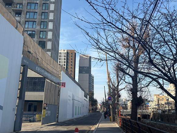 서울 성북구 보문동 '보문 센트럴 아이파크' 시공 현장 뒤로 보이는 '보문 리슈빌 하우스'. [사진=김민지 기자]