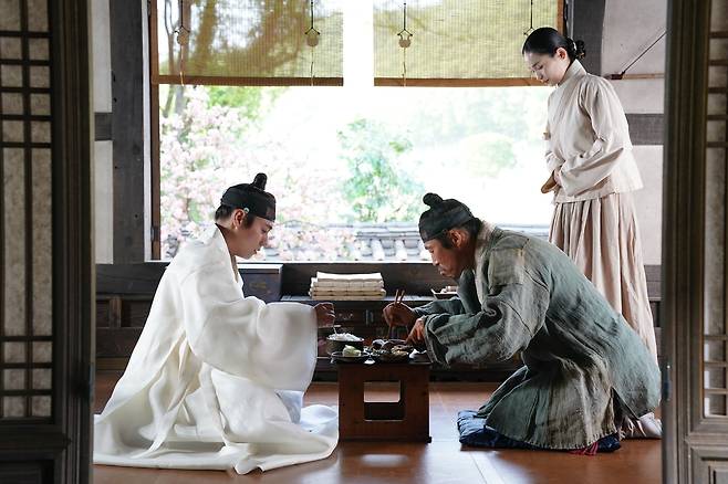 영화 <왕과 사는 남자>에서 왕위에서 쫓겨나고 유배 온 어린 상왕 이홍위(박지훈)와 마을 촌장 엄흥도(유해진)가 밥상을 두고 마주 앉아 있다. 쇼박스 제공