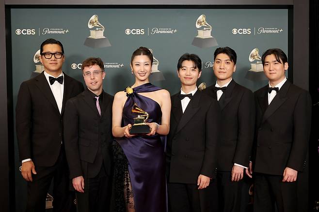 From left: 24, Mark Sonnenblick, Ejae, Lee Yu-han, Park Hong-jun and Nam Hee-dong pose in the press room upon winning the Best Song Written for Visual Media award during the 68th Grammy Awards at Crypto.com Arena in Los Angeles, California, Sunday. (AFP via Yonhap)