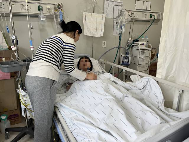 지난달 26일 칠곡경북대학교병원 병실에서 박은영(52·가명) 씨가 급성 복막염을 앓고 있는 딸 현지(18·가명) 씨를 돌보고 있다. 김영경 기자