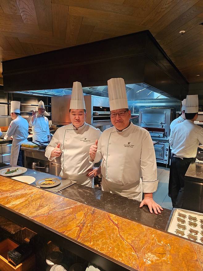 오픈 키친에서 박영진 총주방장과 인현기 부총주방장 그 뒤로 V 포즈의 셰프에서 훈훈한 팀웍을 엿본다(사진=정상미)