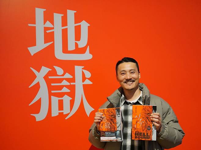 지난달 30일 일본 도쿄 신주쿠 한국문화원에서 열린 K웹툰 전시회에서 최규석 작가가 자신의 작품 '지옥' 한국판·일본판 단행본을 양손에 들고 소개하고 있다. 한국콘텐츠진흥원