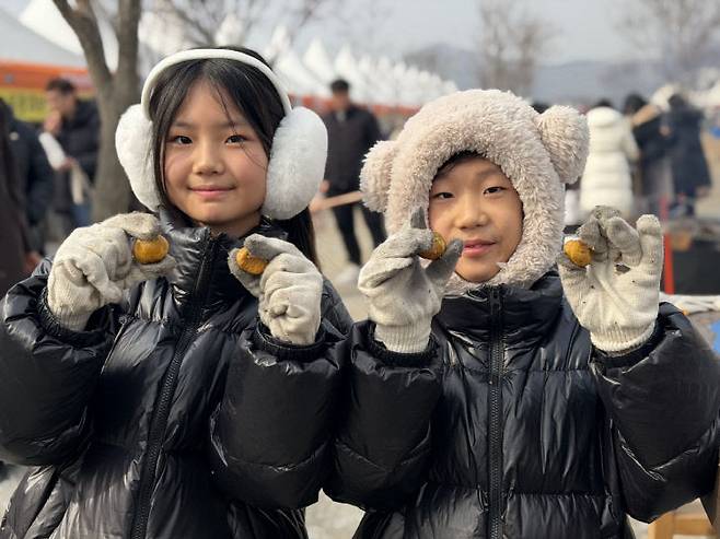공주군밤축제를 찾은 아이들이 군밤을 들어보이며 즐거워 하고 있다. (공주시 제공)