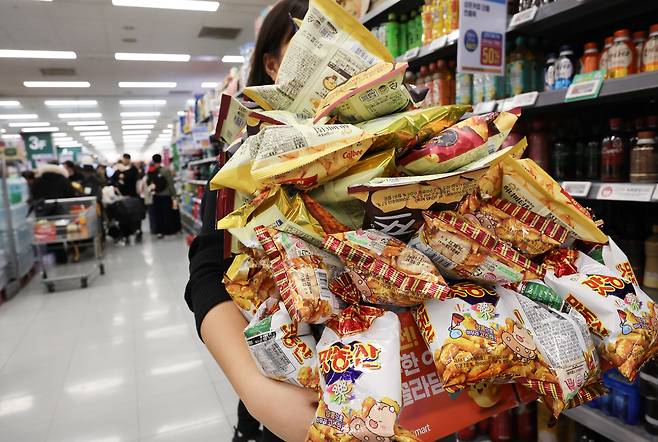 1일 서울 영등포구 이마트 영등포점에서 시민들이 과자를 들고 계산대로 이동하고 있다. 이마트는 지난달 29일부터 2만5000원을 내고 지정된 박스에 과자를 무제한 담을 수 있는 행사를 열고 있다./연합뉴스