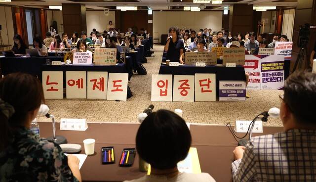2023년 7월31일 서울 중구 로얄호텔에서 시민단체 활동가들이 고용노동부의 `외국인 가사근로자 도입 시범사업’을 `가사노예제도 시범사업\'이라 규탄하는 손팻말을 들고 있다. 강창광 선임기자