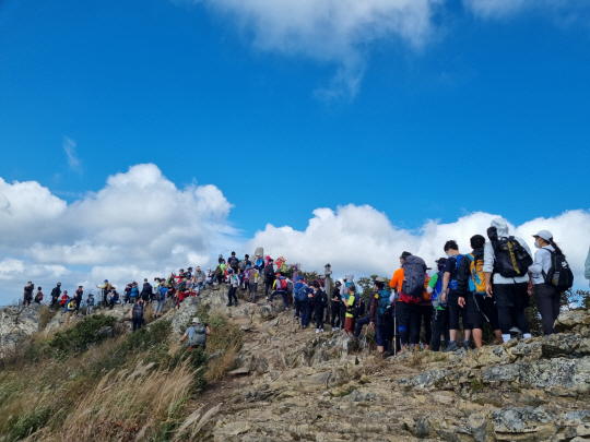 울주 간월산 정상에서 정상인증을 하려고 장사진을 이루는 정상 사냥꾼?들. 이 부작용으로 울주군은 인증방식 일부를 수정했다&nbsp; 사진 울주군청