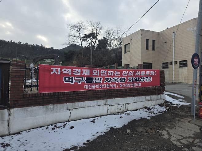 출퇴근은 당진으로, 대산읍 일대에 게시된 현수막. 대산읍 이장단협의회와 주민단체는 관외 소비와 인구 유출을 부추기는 교통·생활 인프라 문제를 지적하며, 근본 대책 마련을 요구하고 있다. 독자 제공