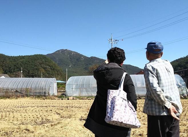 2021년 10월23일, 진실화해위 김애자 조사관(왼쪽)이 전남 화순군 백아면(옛 북면) 수리마을에서 이 마을 주민 김아무개씨에게 1950년 12월 이 마을에서 벌어진 총살 사건에 대한 증언을 듣고 있다. 1937년생인 김씨는 1950년 12월12일 16명의 수리마을 주민이 국군에 의해 희생됐다고 증언했다. 멀리 보이는 산이 백아산이다. 진실화해위 제공