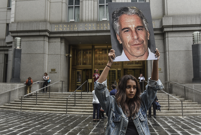 2019년 7월 미국 뉴욕 연방 법원 앞에서 시위 단체 ‘핫 메스(Hot Mess)’ 소속 인사들이 제프리 엡스타인의 얼굴이 담긴 피켓을 들고 시위를 벌이고 있다. 당시 엡스타인은 미성년자 성매매 및 성매매 공모 혐의로 기소될 예정이었다. 게티이미지