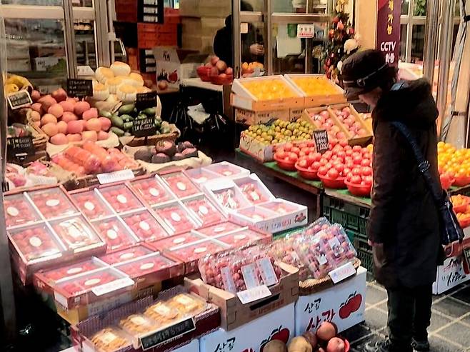 통시장에서 한 소비자가 과일값을 확인하고 있다. / 사진=김도영 인턴기자