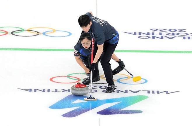 컬링 믹스더블 국가대표 김선영과 정영석이 5일(현지시간) 이탈리아 코르티나담페초 컬링 올림픽 스타디움에서 열린 밀라노·코르티나 동계올림픽 예선 경기에서 스위핑을 하고 있다.   [사진 제공= 연합뉴스]