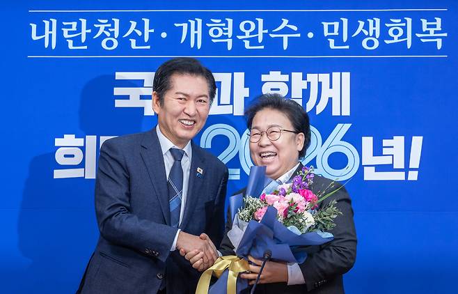 더불어민주당 정청래 대표(왼쪽)가 지난달 12일 국회에서 열린 최고위원회의에서 신임 문정복 최고위원에게 꽃다발을 전달하고 있다. /연합뉴스