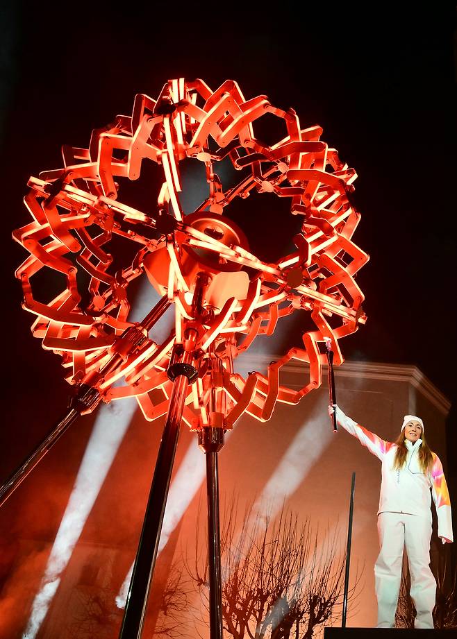 최종 성화봉송 주자인 이탈리아 스키 선수 소피아 고지아가 6일(현지시간) 이탈리아 코르티나 담페초에서 열린 2026 동계 올림픽 개막식에서 성화대에 불을 붙이고 있다. AP연합뉴스