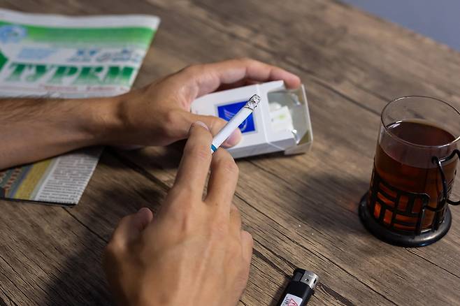 한 남성이 담배를 피우는 모습 [사진 출처 = AFP 연합뉴스]