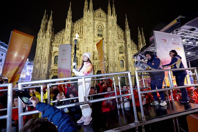 2월 5일 저녁 이탈리아 밀라노 두오모 대성당 앞 광장에서 2026 밀라노 코르티나 동계 올림픽 성화봉송이 열리고 있는 가운데 마지막 주자인 니콜레타 마니 이탈리아 발레 무용수가 성화를 점화대로 옮기고 있다. 밀라노=장련성 기자