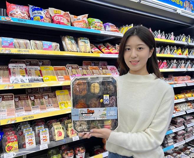 GS25에서 모델이 2026년 설 명절 도시락을 들고 포즈를 취하고 있다.ⓒGS25