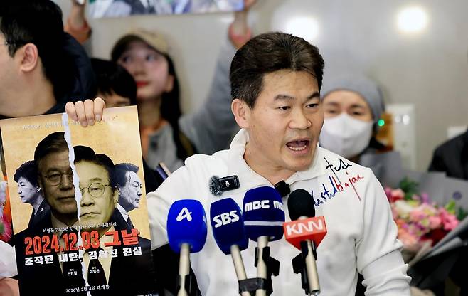 전한길 전 한국사 강사가 지난 3일 인천국제공항 제2여객터미널로 귀국해 기자회견에서 자신이 제작한 영화 포스터를 들어보이고 있다. 2026.2.3/뉴스1