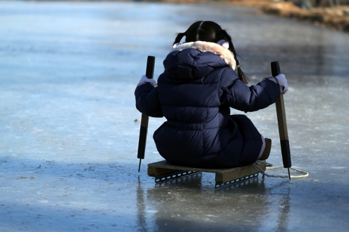 추운 날씨가 이어진 지난 1월 27일 강원 속초시 도문동에서 한 어린이가 얼음 썰매를 체험해 보고 있다. [속초=연합뉴스]