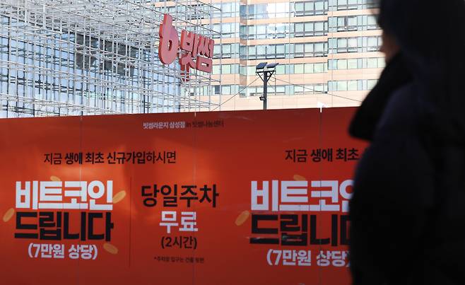 8일 서울 강남구 빗썸라운지 삼성점 앞에 빗썸 신규 가입자에게 7만원 상당의 비트코인을 무료로 제공한다는 내용의 이벤트 홍보물이 붙어 있다. 연합뉴스