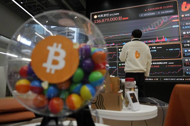 An employee watches an electronic signboard displaying the prices of Bitcoin and other cryptocurrencies at the lounge of Bithumb cryptocurrency exchange in Seoul, on Nov. 21, 2024. [AP/YONHAP]