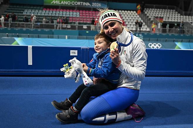 8일 이탈리아 밀라노의 밀라노 스피드스케이팅 스타디움에서 열린 밀라노·코르티나 2026 동계올림픽 스피드스케이팅 여자 3000m 경기에서 금메달을 획득한 이탈리아의 프란체스카 롤로브리지다가 아들 토마소와 함께 포즈를 취하고 있다. [AFP\