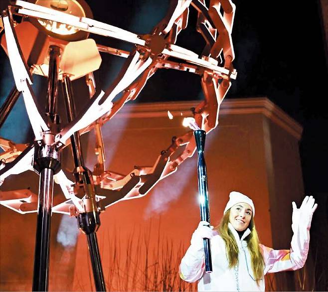 AFP 연합뉴스이탈리아의 알파인스키 스타 소피아 고자가 코르티나 디보나 광장에 설치된 성화대에 불을 붙이고 있다.