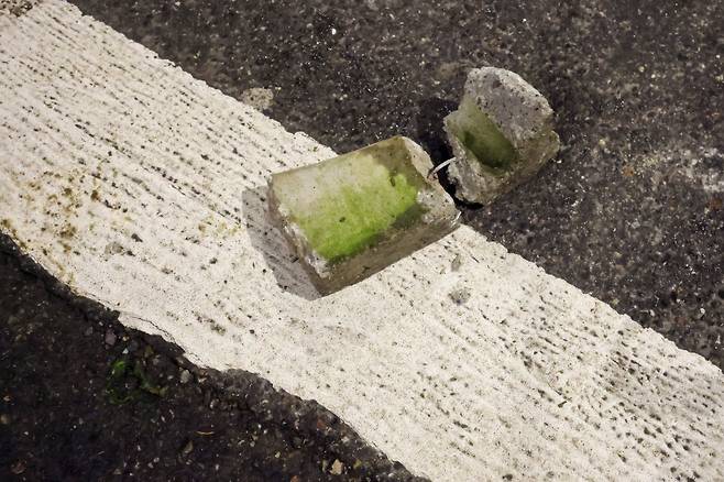 2월 7일 오후(현지시간) 이탈리아 밀라노에서  '지속 불가능한 올림픽 위원회'가 주최한 올림픽 반대 집회가 열렸다. 이번 집에는 그린피스 등 단체가 연합해 밀라노 메달리에 도로(piazza medaglie d'oro)에서 시작해 시내 곳곳을 행진한 뒤 코르베토역 인근 도로에서 홍염을 피우며 경찰 차벽을 향해 불꽃과 벽돌 그리고 유리병을 던졌다. 이날 시위로 시위대 6명이 경찰에 체포 됐다. 사진은 시위대가 경찰 차벽 바로 앞 표지판에 던진 벽돌의 모습. 밀라노=장련성 기자