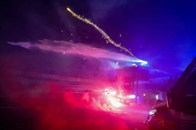 2월 7일 오후(현지시간) 이탈리아 밀라노에서  '지속 불가능한 올림픽 위원회'가 주최한 올림픽 반대 집회가 열렸다. 이번 집에는 그린피스 등 단체가 연합해 밀라노 메달리에 도로(piazza medaglie d'oro)에서 시작해 시내 곳곳을 행진한 뒤 코르베토역 인근 도로에서 홍염을 피우며 경찰 차벽을 향해 불꽃과 벽돌 그리고 유리병을 던졌다. 이날 시위로 시위대 6명이 경찰에 체포 됐다. 경찰이 시위대를 향해 물대포와 최루탄을 쏘고 있다. 밀라노=장련성 기자