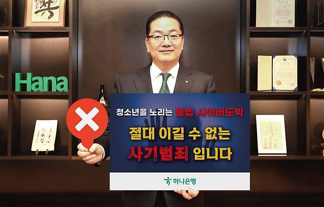 이호성 하나은행장이 서울 중구 하나은행 을지로 본점에서 청소년 불법도박 근절 릴레이 캠페인에 동참하기 위해 '청소년을 노리는 불법 사이버 도박, 절대 이길 수 없는 사기 범죄입니다'라는 메시지를 담은 피켓을 들고 사진을 촬영하고 있다.ⓒ하나은행