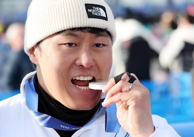 스노보드 남자 평행 대회전에서 값진 은메달을 획득한 김상겸이 8일(현지시간) 이탈리아 리비뇨의 스노파크에서 열린 2026 밀라노·코르티나담페초 동계올림픽 스노보드 남자 평행 대회전 시상식을 마친 뒤 메달을 깨물며 기뻐하고 있다. 2026.2.8 ⓒ 뉴스1