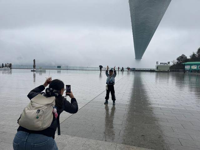 구이저우성이 고향인 탄징이(38)가 3일 중국 구이저우성 화장협곡대교 아래에서 아들의 사진을 찍어주고 있다. 안순(구이저우성)=이혜미 특파원