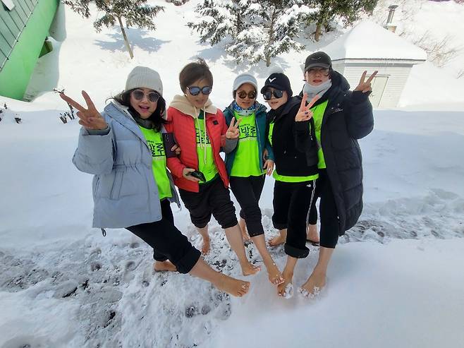제1회 울릉 눈꽃 맨발 걷기 축제에 참여한 여성 동호인들이 울릉도의 은빛 설원 위에서 맨발을 들어 보이며 환한 미소로 선전을 외치고 있다. /울릉크루즈 제공