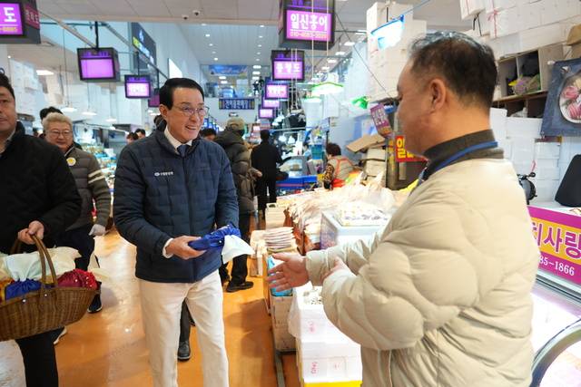 10일 노동진 수협중앙회장(사진 왼쪽)이 서울 동작구 노량진수산시장을 방문해 수산물 판매와 시장 발전에 힘쓰고 있는 시장 상인들에게 감사의 뜻을 담아 설 격려 엽서, 떡, 핸드크림 등이 담긴 복주머니를 전달하고 있다. 수협 제공