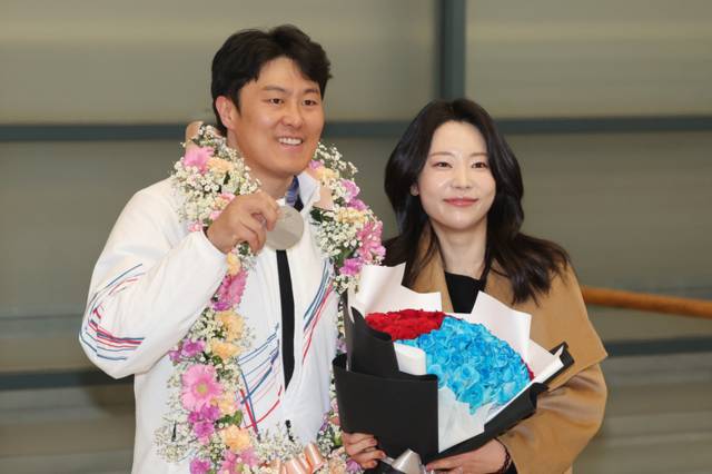 ▲ 2026 밀라노-코르티나담페초 동계 올림픽 스노보드 남자 평행대회전에서 은메달을 차지한 한국 스노보드 국가대표팀 김상겸(왼쪽)이 10일 인천국제공항을 통해 귀국한 뒤 아내와 기념 촬영하고 있다. 연합뉴스