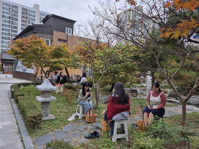 (주)지방이 운영하는 양조장 ‘흑화양조’ 뒤 정원에서 관광객들이 술지게미를 이용한 족욕 체험을 하고 있다. 지방 제공