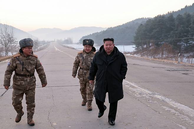 In this photo released by the Rodong Sinmun on Jan. 5, North Korean leader Kim Jong-un, right, walks down a road near the site of what the newspaper described as a "hypersonic missile launch test" that took place the previous day. [NEWS1]