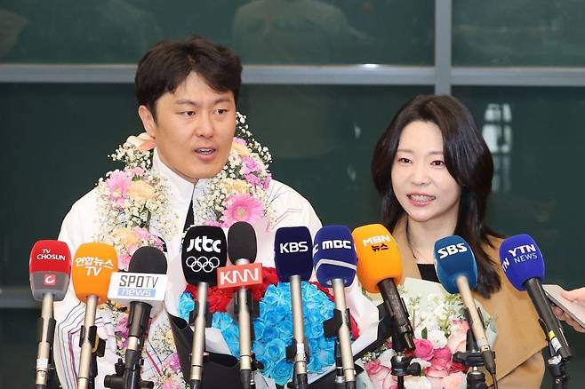 2026 밀라노·코르티나담페초 동계올림픽 스노보드 남자 평행대회전에서 은메달을 획득한 김상겸이 10일 인천국제공항에서 취재진의 질문에 답하고 있다. 오른쪽은 아내 박한솔씨 연합뉴스