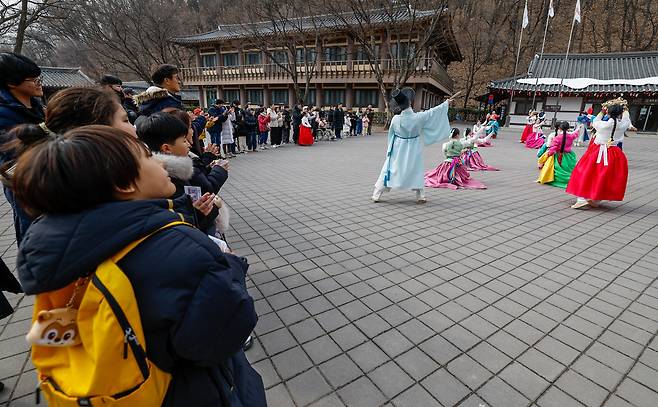 설 연휴를 앞둔 10일 경기 용인시 한국민속촌에서 관람객들이 민속 퍼레이드 공연 ‘백년가약’을 지켜보고 있다.