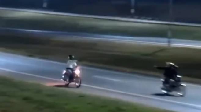 사복을 입은 경찰(하얀 티)이 오토바이를 탄 2인조 강도단을 추격하면서 총격전을 벌이고 있다. CCTV 캡처