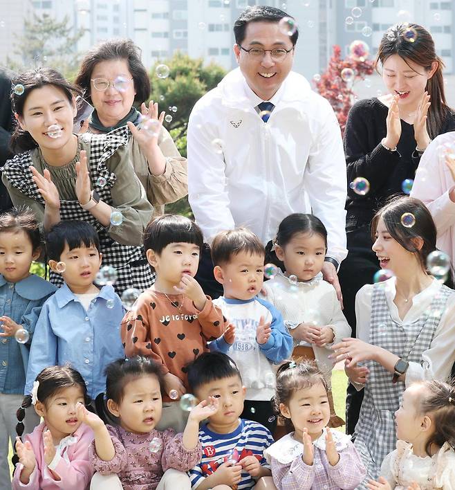 대전 동구는 인구 30만 명 회복을 위해 머물고 정착하는 도시로 전환하고 아이와 가족, 청년 세대를 아우르는 인구정책 추진하고 있다고 10일 밝혔다. 사진은 박희조 대전 동구청장(뒷줄 왼쪽에서 세 번째)이 관내 아이들과 버블쇼를 보는 모습. 동구 제공