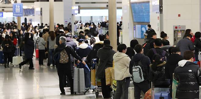 설 명절 연휴를 앞둔 11일 인천국제공항 제1여객터미널 출국장에서 승객들이 탑승 수속을 위해 줄을 서고 있다. [연합]