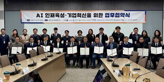 경기도일자리재단이 11일 시흥시청에서 시흥시 등 10개 유관기관과 'AI 인재 육성 및 기업 혁신을 위한 업무 협약'을 체결한 뒤 기념 사진을 찍고 있다. 경기도일자리재단 제공