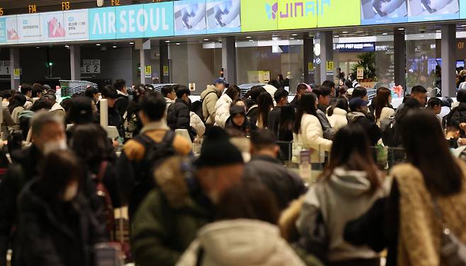 설 명절 연휴를 앞둔 지난 11일 인천국제공항 제2여객터미널 출국장에서 승객들이 탑승 수속을 위해 줄을 서고 있다. [연합]