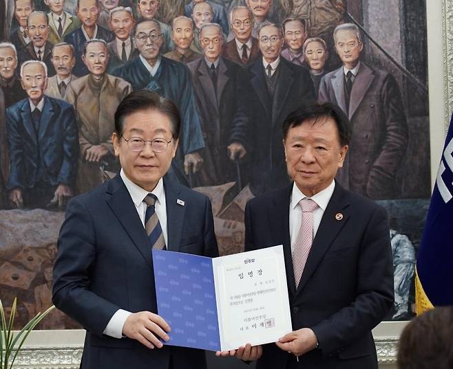 더불어민주당 세계한인민주회의 원외부의장으로 임명된 심상만 세한총연 명예회장 지난해 3월 국회에서 당시 이재명 세계한인민주회의 의장으로부터 원외부의장으로 임명된 심상만 세계한인총연합회 명예회장. [이기헌 의원실 제공. 재판매 및 DB 금지]