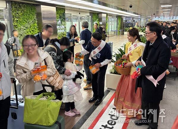 제주도관광협회가 13일 제주를 방문하는 관광객들에게 기념품을 전달하며 환영 행사를 진행하고 있다. (사진=제주도관광협회)