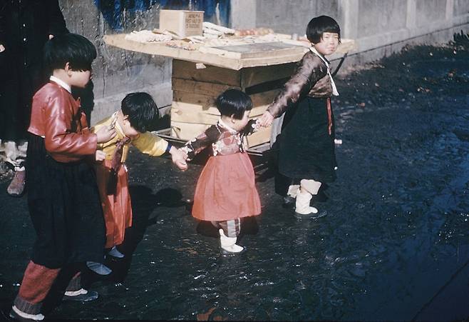 1948년 음력 설을 앞두고 한복을 곱게 차려 입은 소녀들이 동생들 손을 잡고 걷고 있다. / 눈빛 아카이브