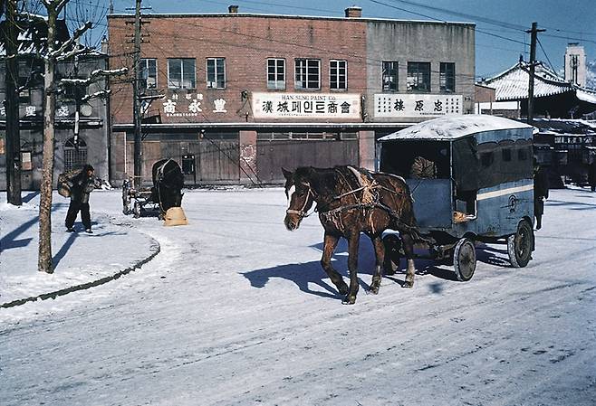 1948년 서울거리에서 말이 끄는 일종의 '마차 택시'가 눈 덮힌 길 위를 달리고 있다. / 눈빛 아카이브
